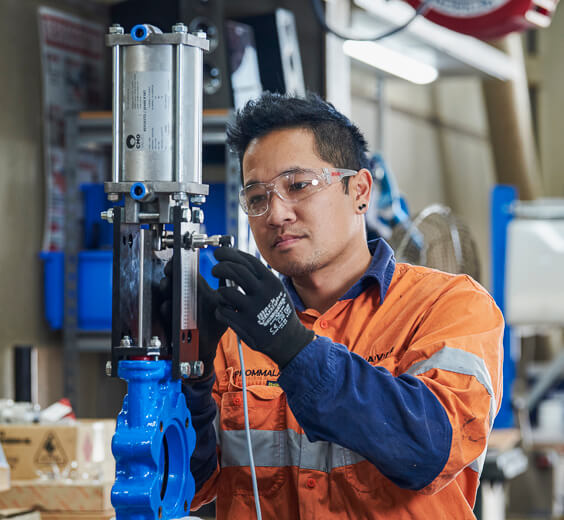 A valve technician working on a seated knife gate valve in our workshop