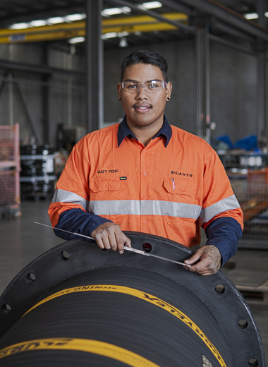 A team member measuring the integral flange on a custom made hose