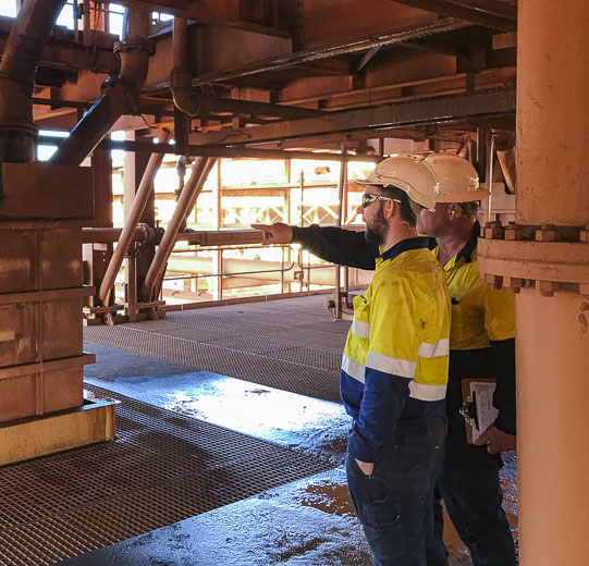 A maintenance super pointing out areas of his processing plant