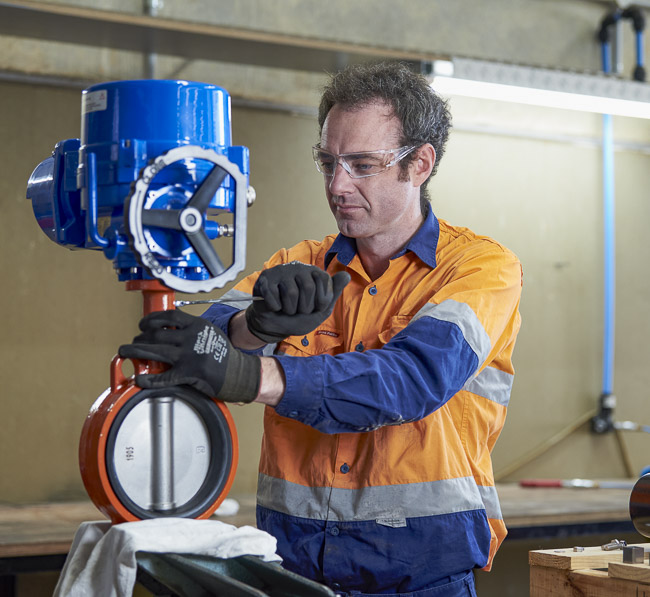 A technician fitting an actuator to a butterfly valve
