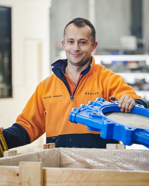 A team member packing a refurbished valve in a crate