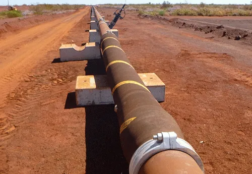 Beaver Abrasiguard lined slurry pipeline running across iron ore terrain at Mesa A